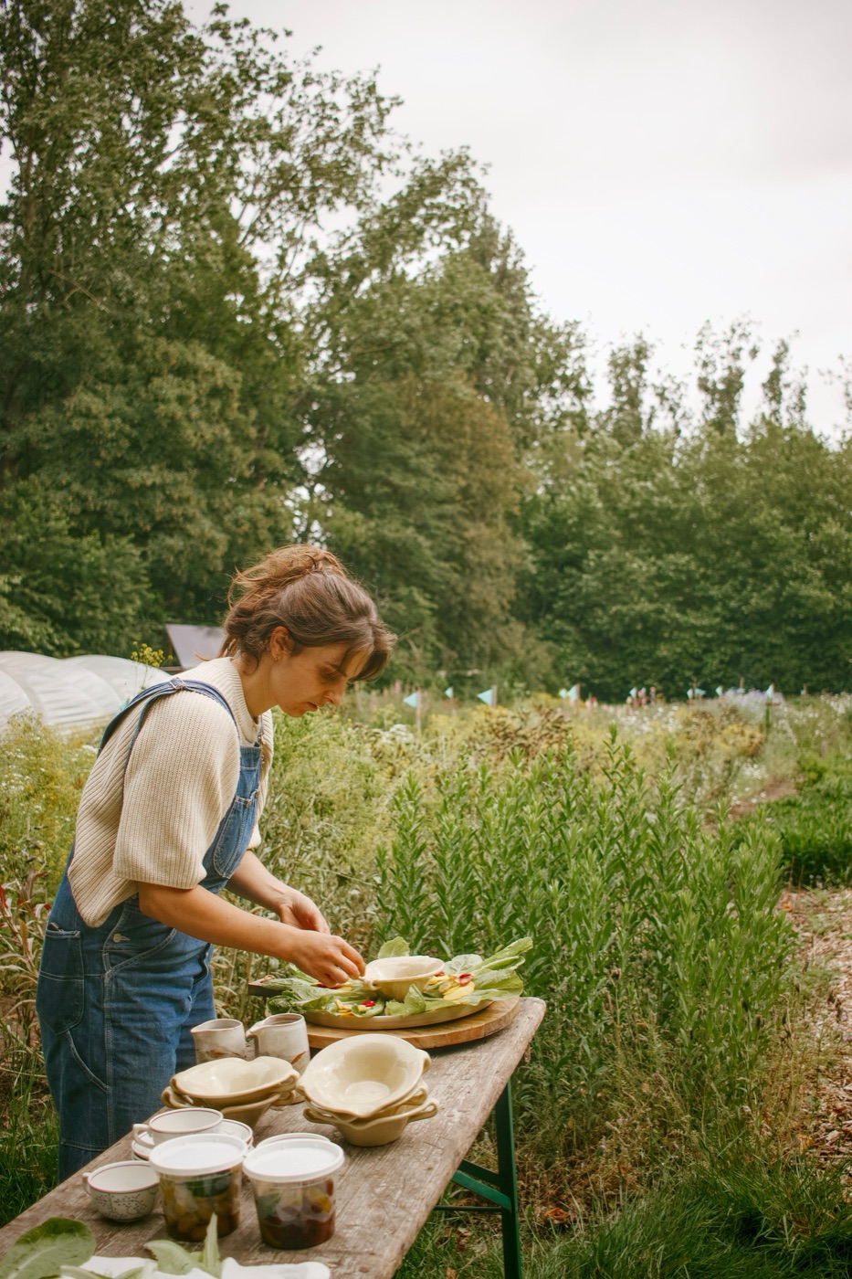 Eva dekt een tafel buiten tussen de velden